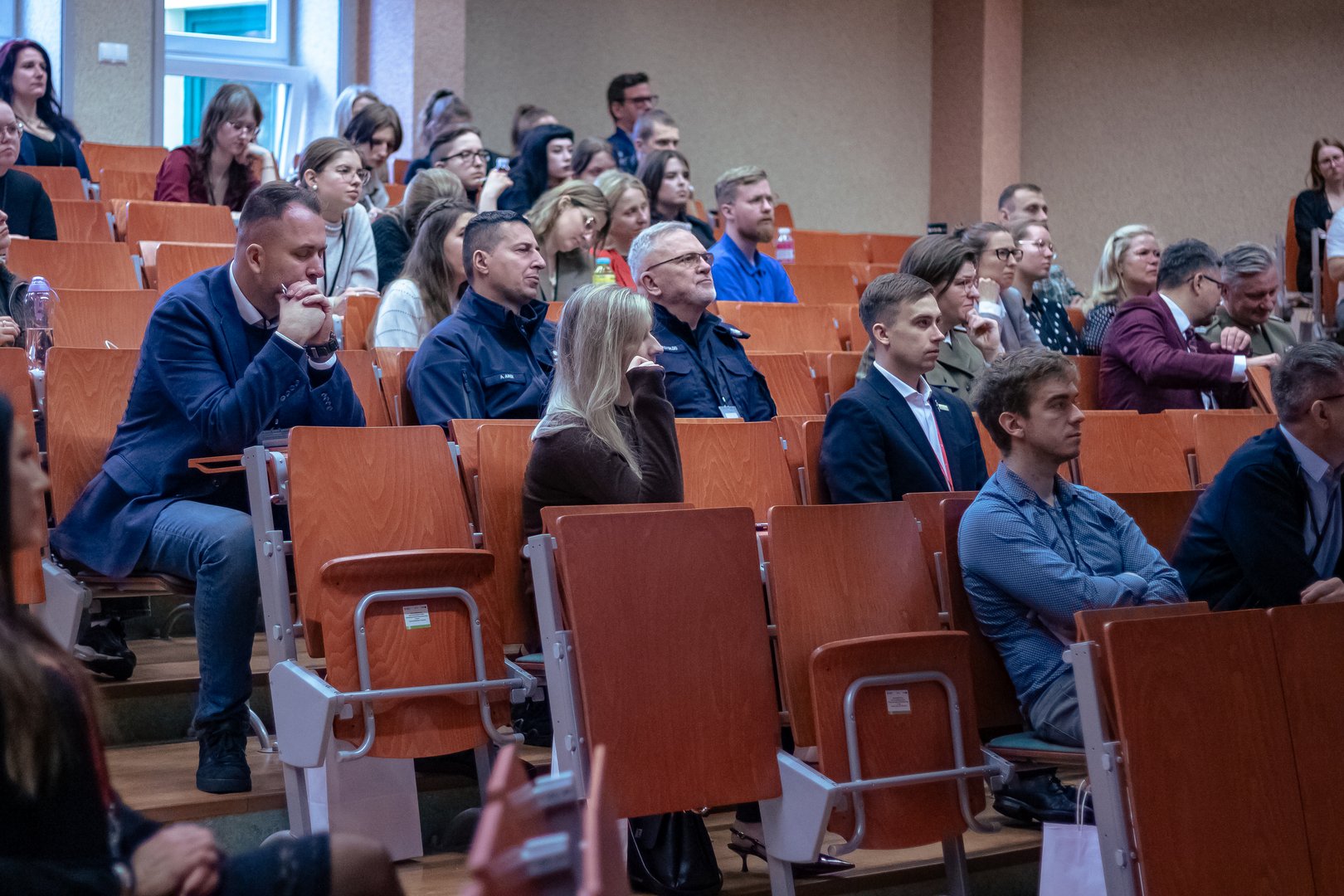 Sala konferencyjna pełna ludzi i komendant policji
