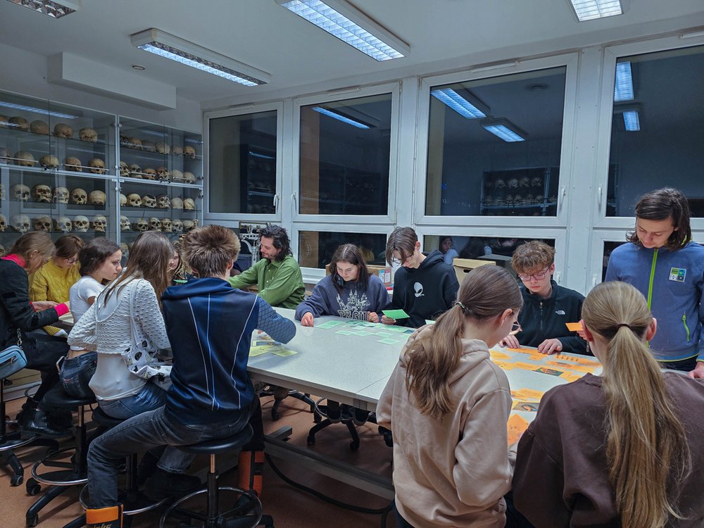 Grupa ludzi przy stole z kolorowymi kartkami