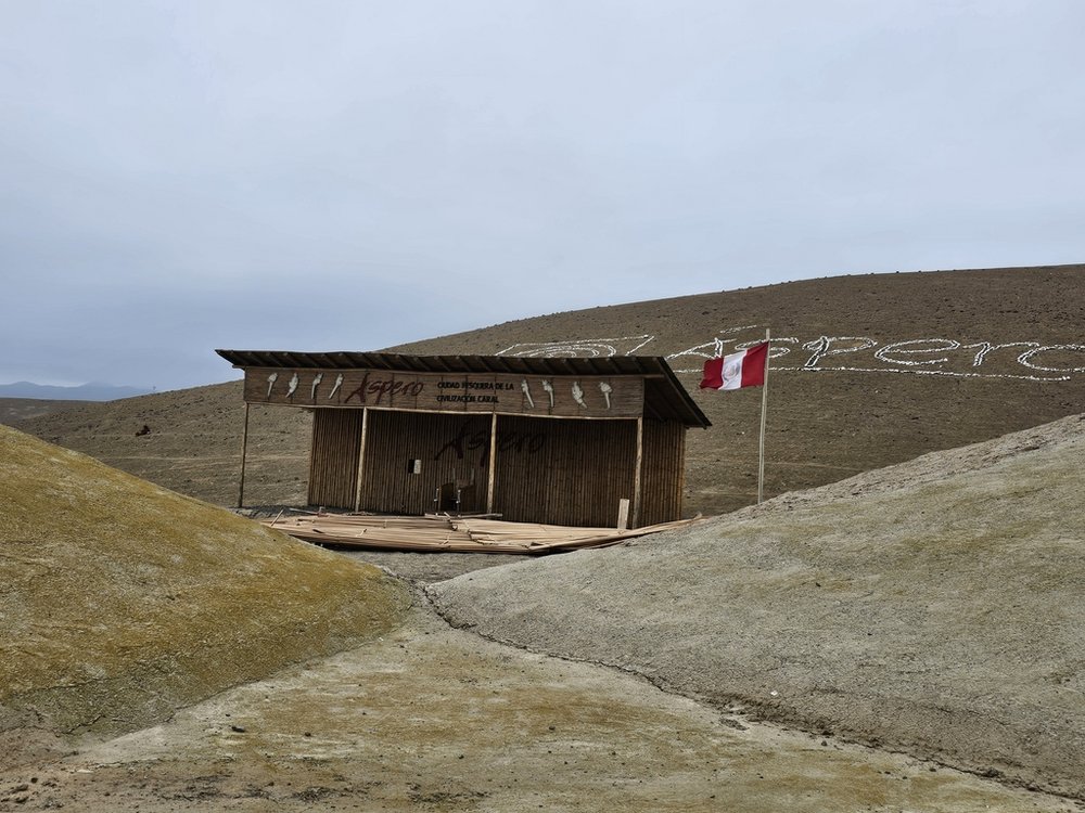 drewniana chatka oraz napis Aspero na wzgórzu 