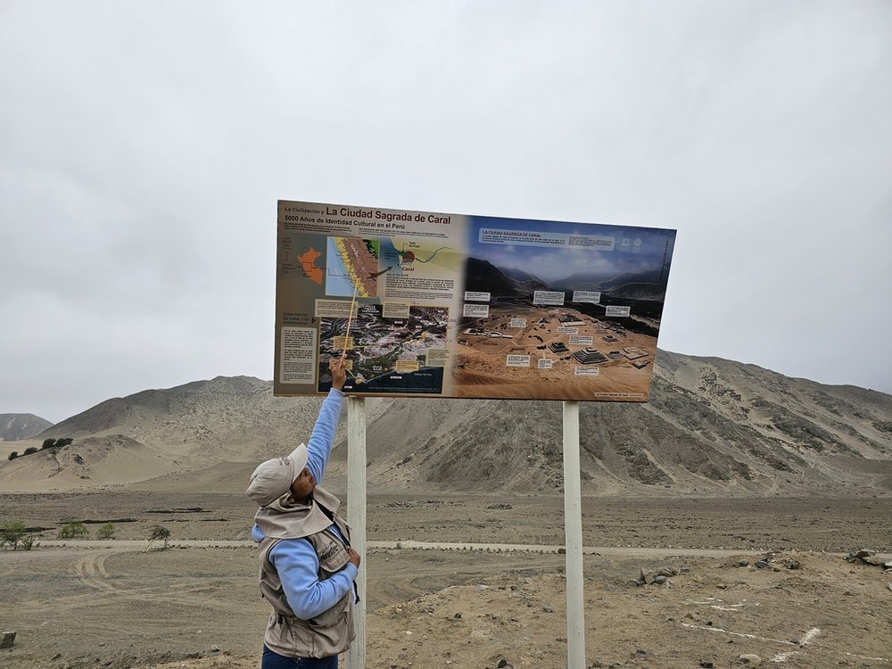 osoba pokazująca tablicę informacyjną wzgórza