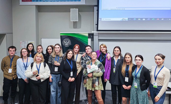 Grupowe zdjęcie członków Koła na tle sali konferencyjnej