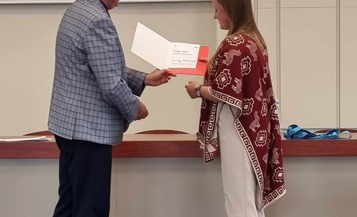 Organizator Konkursu wręcza dyplom i przekazuje gratulacje wygranej w konkursie Karinie Woźniak