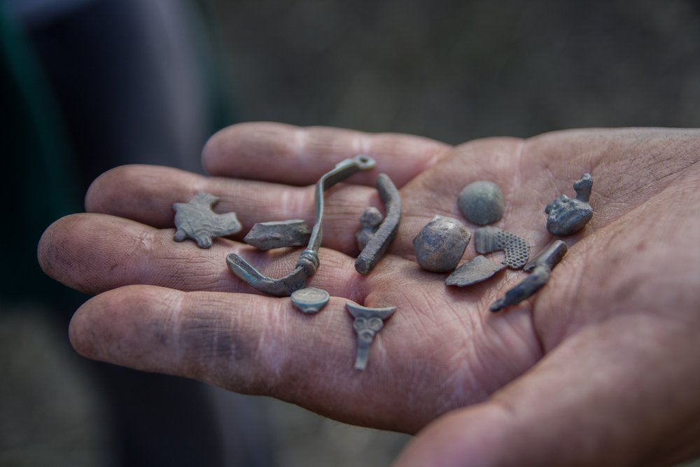 Zbiór metalowych małych zabytków na dłoni