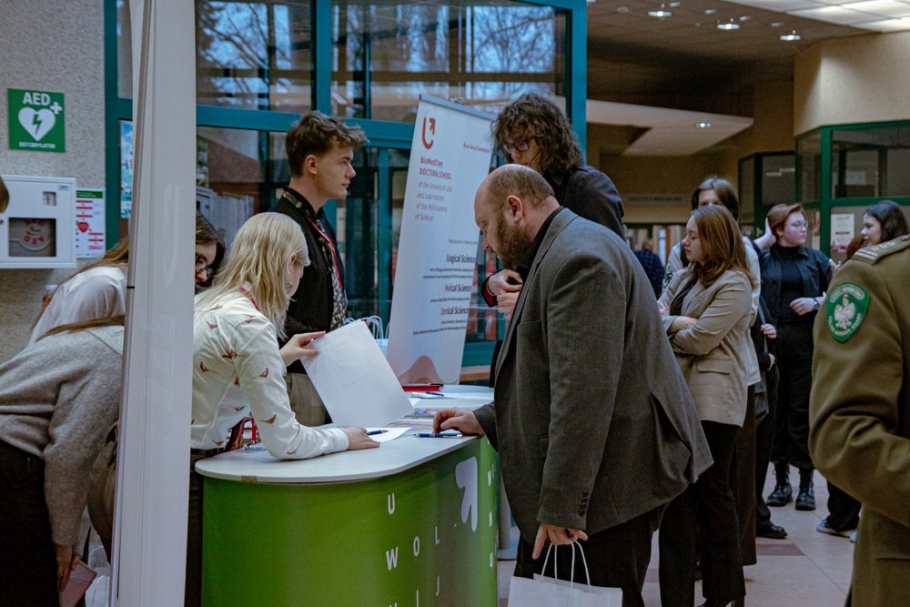 Grupa ludzi przy stanowisku rejestracji