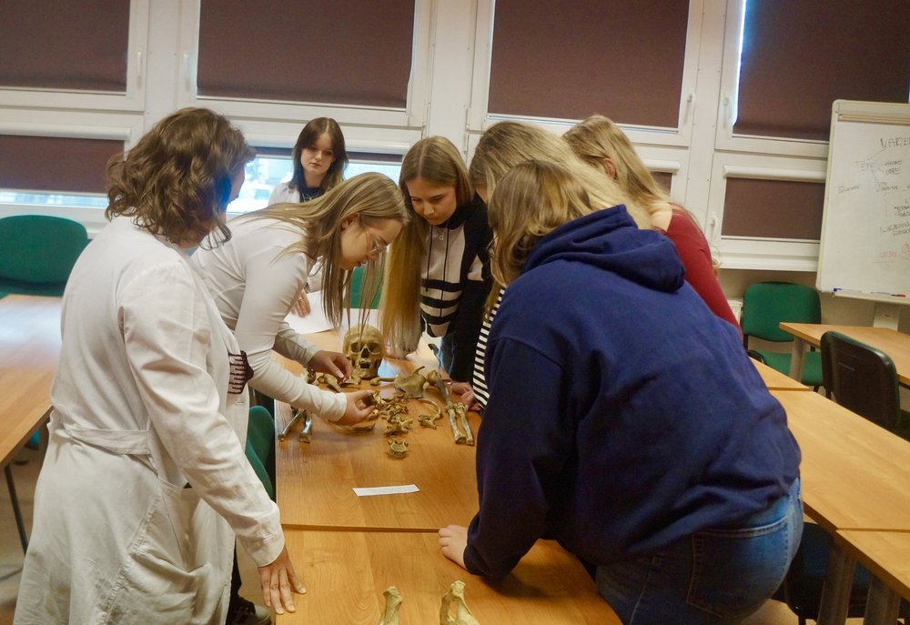 Licealiści przy stole z kośćmi 