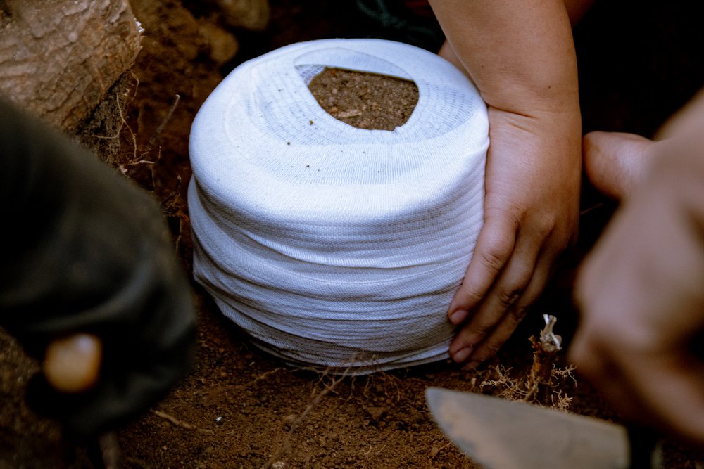 moment wydobycia owiniętej bandażem popielnicy z ziemi