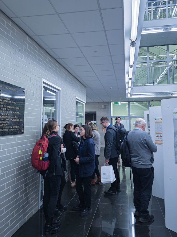 Grupa ludzi uczestniczących w konferencji na korytarzu UKSW w Warszawie