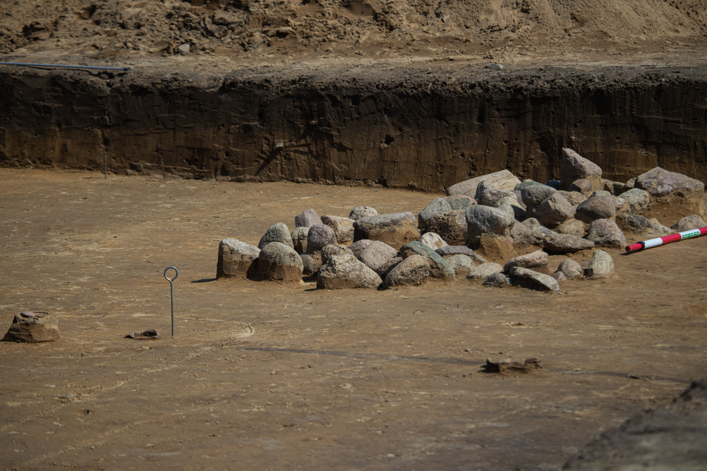 kamienie ułożone na średniowiecznym grobie na stanowisku archeologicznym