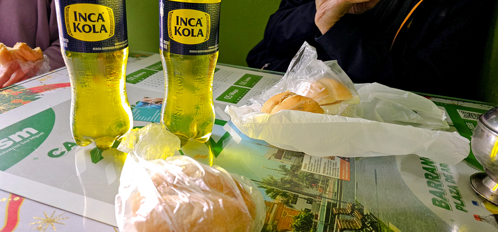 dwie butelki z napojem i dwie kanapki w foliówkach